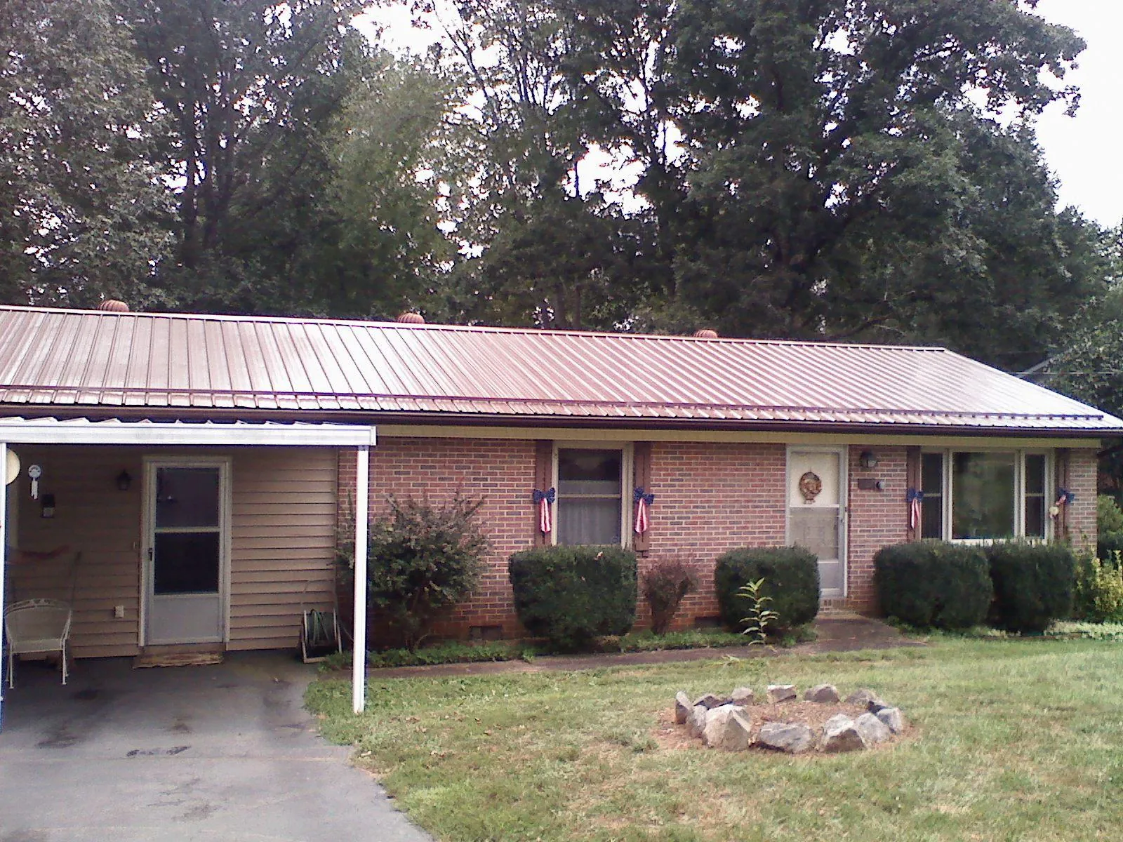 Bronze metal roof and carport on a brick ranch home — Roof Repair work by our crew in Middleton